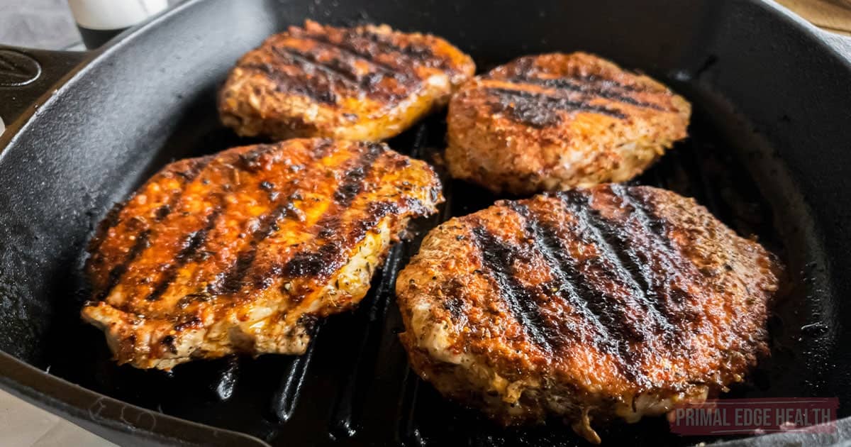 Four pork chops in cast iron grill pan.