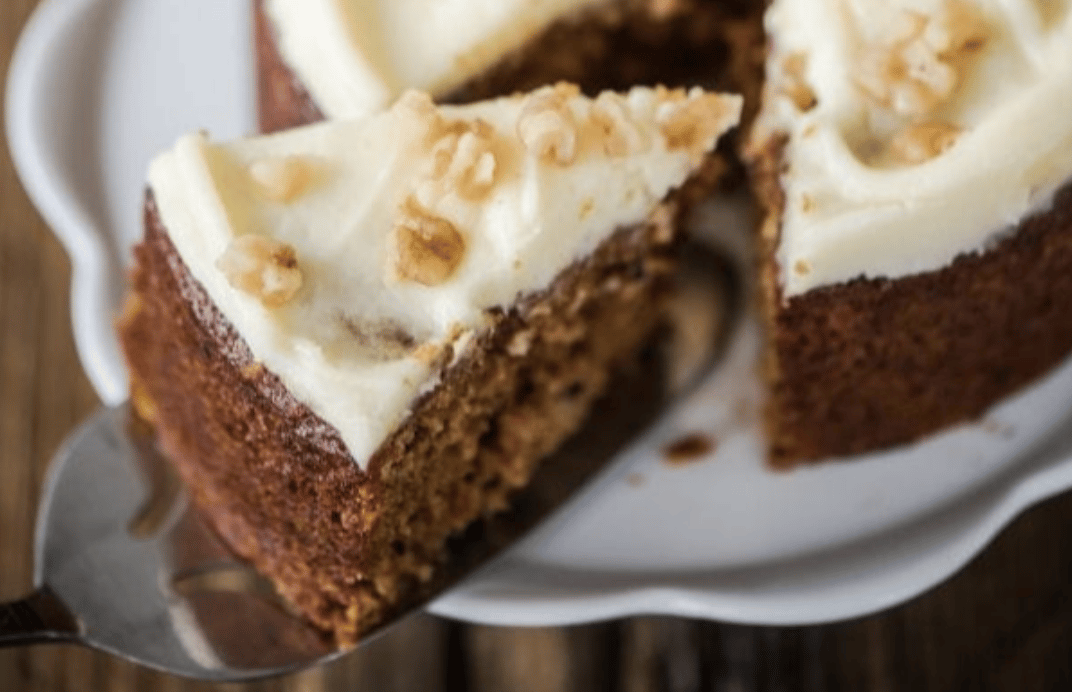 Carrot cake being lifted from full cake.