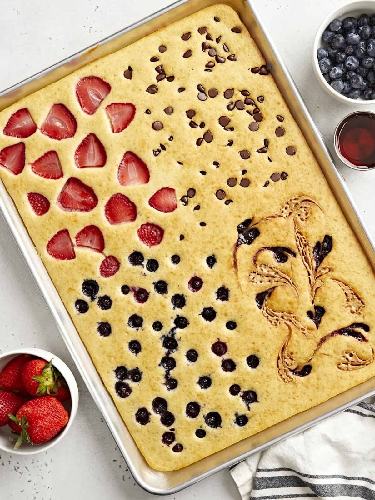 sheet pan pancakes baked in sections with strawberries, blueberries, and chocolate chips for an easy weekend breakfast used in Gina's Friday Finds 5-1-2026
