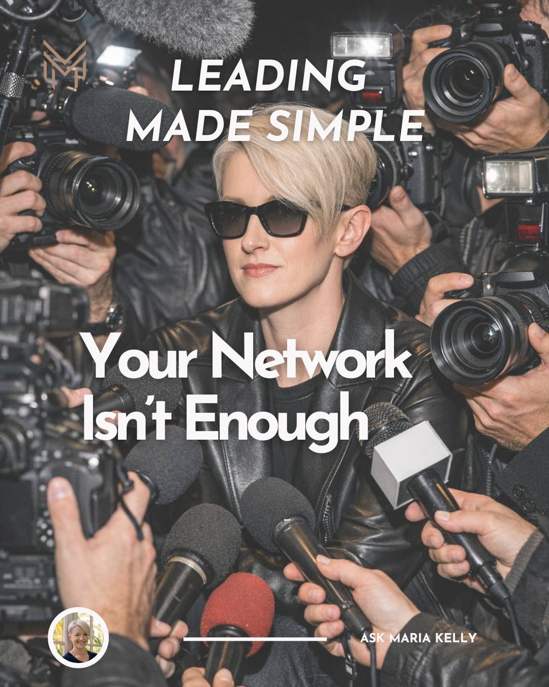 A woman with short blonde hair, black glasses, and a black leather jacket, in the middle of loads of paparazzi, cameras, and microphones 