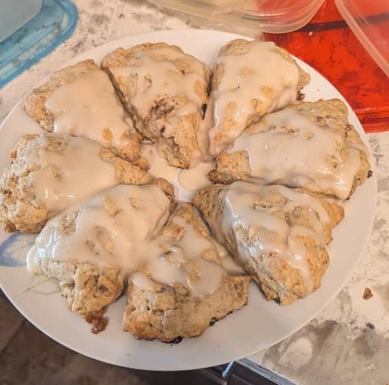 Eight glazed scones sitting on a white plate.