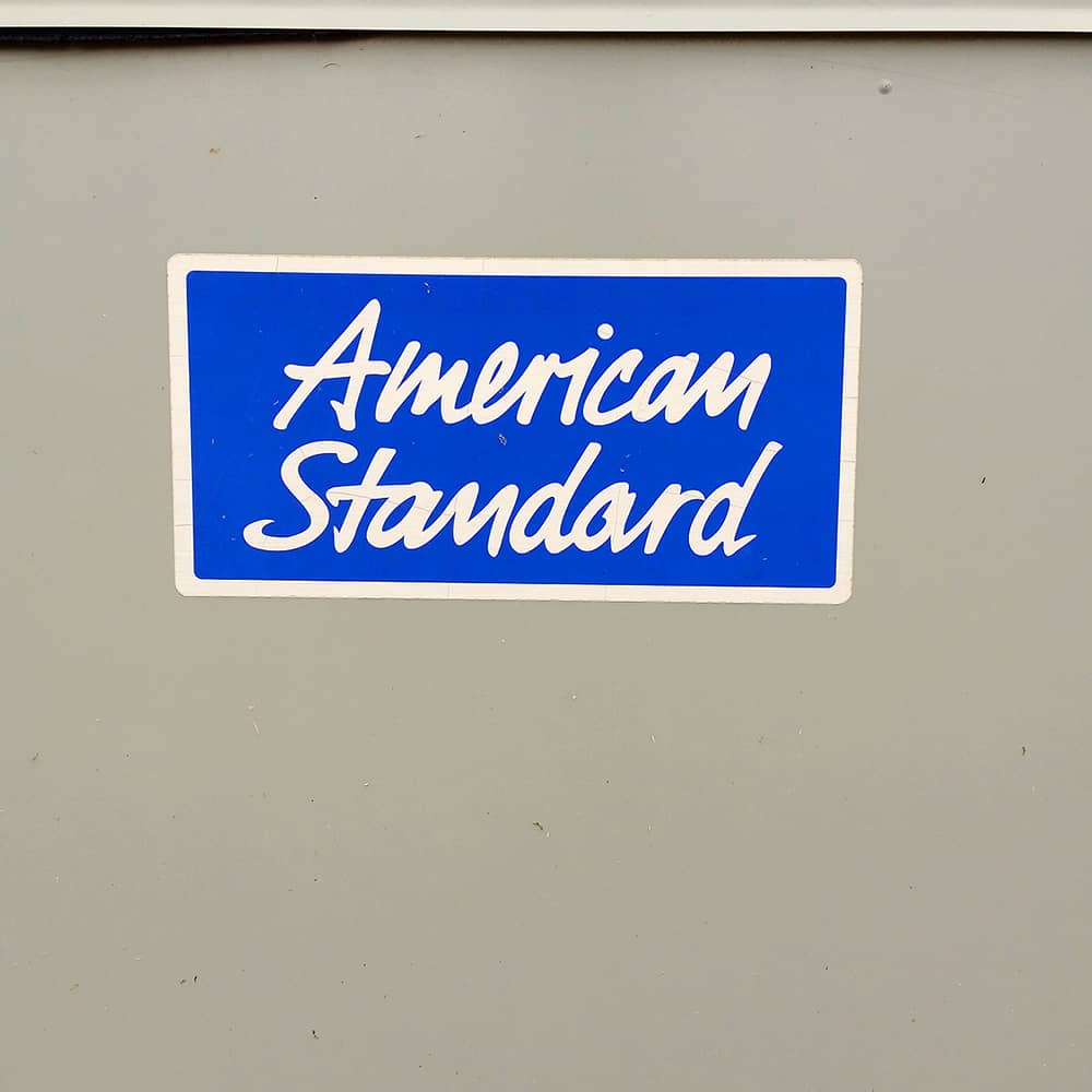 Photo of a beige surface with a blue and white sign that says American Standard/