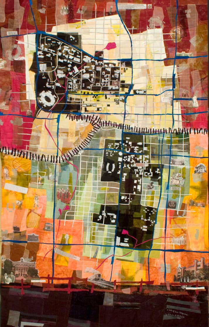 Tale of Two Campuses by Valerie Goodwin. This 48" x 60" quilt from 2010 is visually similar to a map. It uses fabrics in red, orange, pink, green, white, blue, and other colors. It is bisected by a line resembling a railroad. Click image to view source.