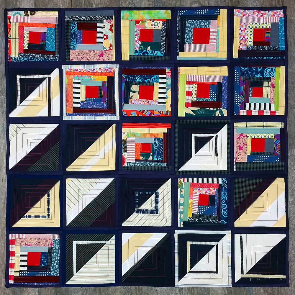 A patchwork quilt titled Ban Logic, made in 2018 by Sarah Atlee. The quilt is a variation on the "Sunshine and Shadows" configuration of a traditional Log Cabin quilt design.