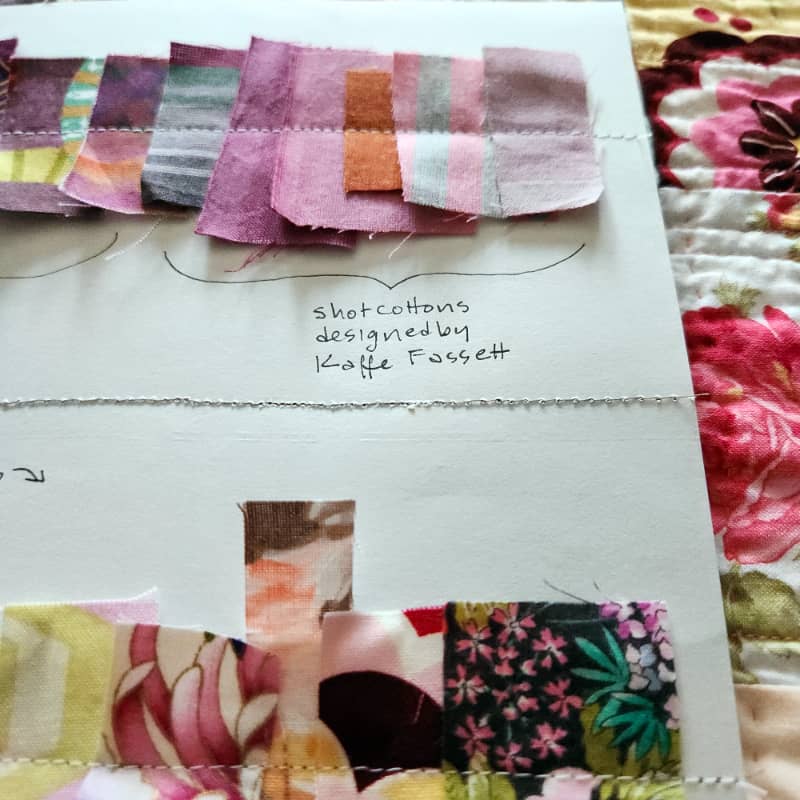 Close up view of a piece of paper with tiny bits of fabric sewn onto it. Sarah's handwriting says "shot cottons designed by Kaffe Fassett."