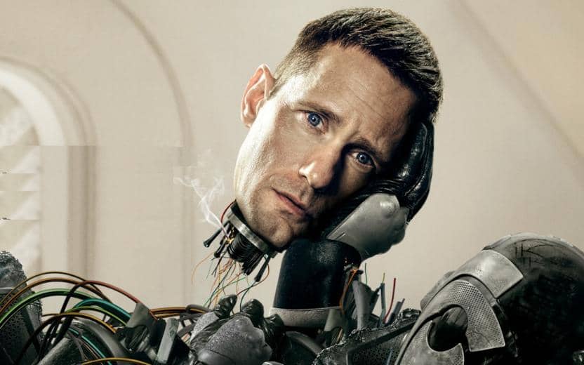 Promotional graphic for the Apple+ tv show Murderbot. Alexander Skarsgard's head is being held by a robotic hand above a pile of rubble.
