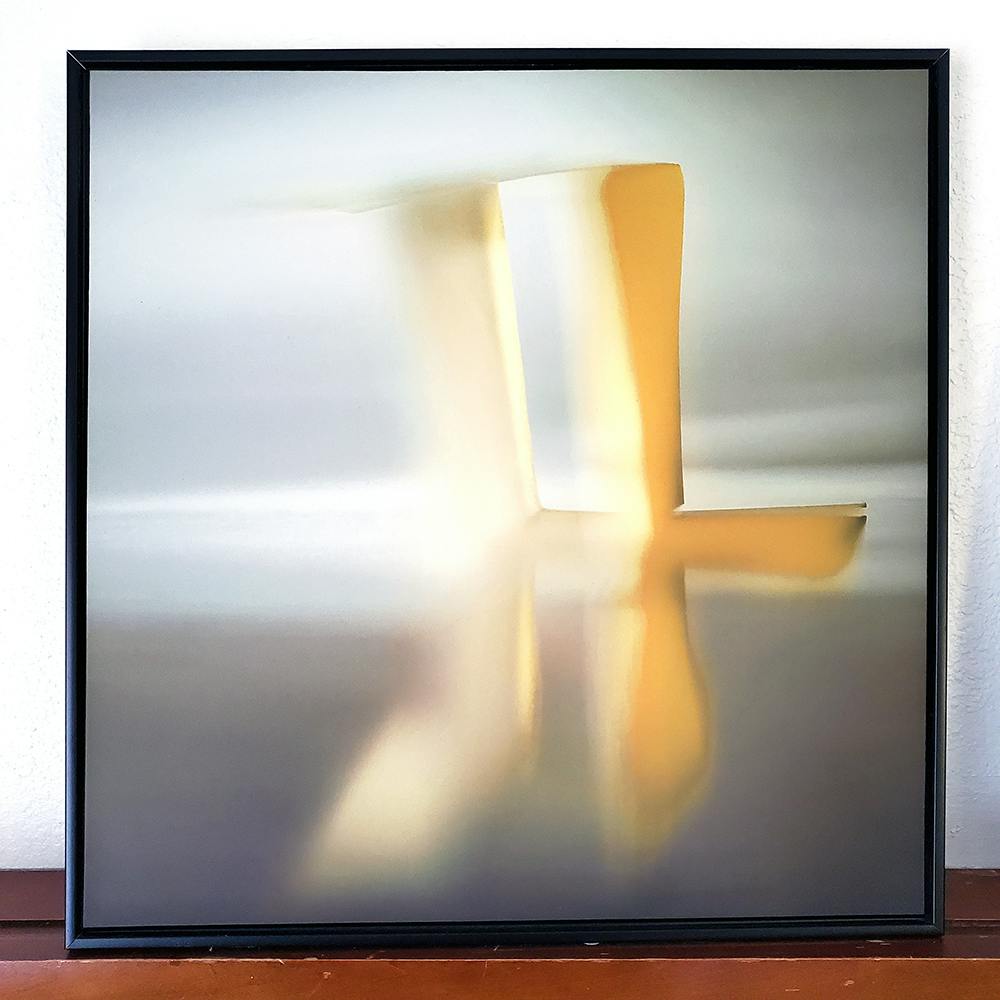 Photo of framed hotel art. The image is an abstract view of folded paper.