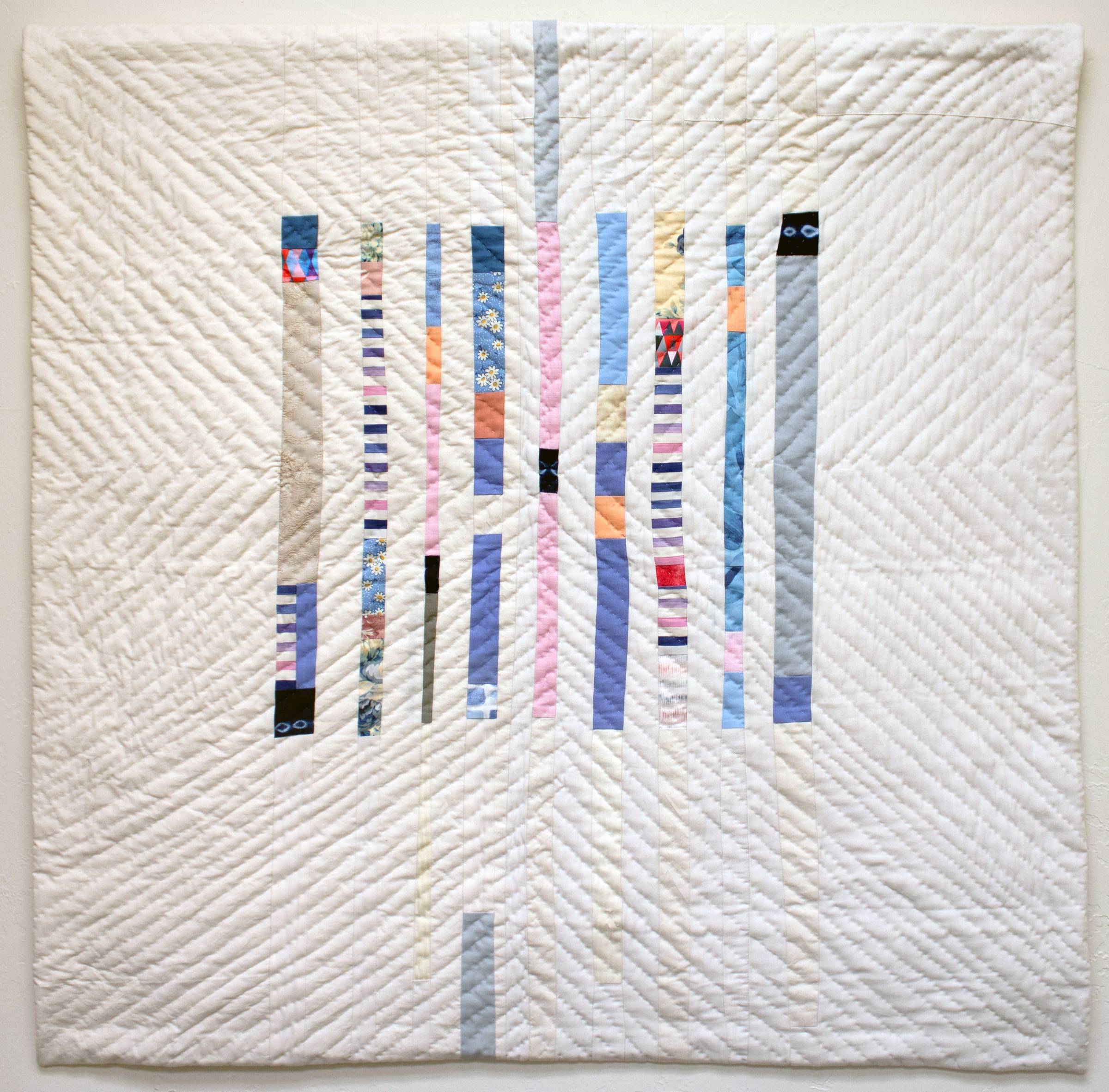Photo of a patchwork quilt titled Portals for Kevin 3: Portal for Nex. The quilt is mostly off-white fabric, with nine vertical columns of multicolored fabric in the middle. The quilt is hand-quilted in diagonal lines radiating from the center.