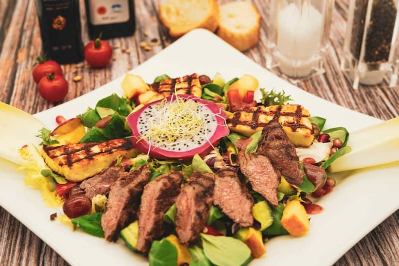 Grilled steak salad with fruits and greens