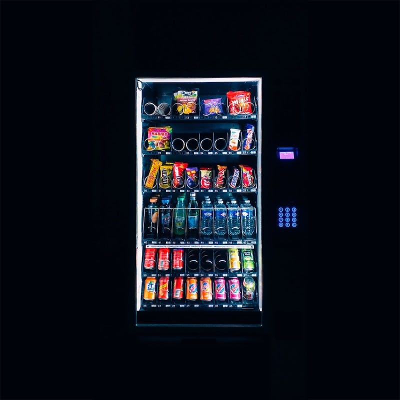 A vending machine, all lightened up, in a dark room