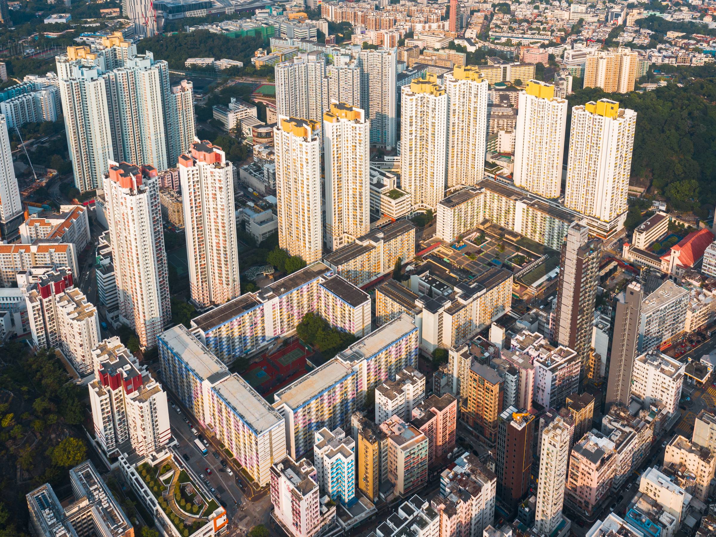 An aerial view of a modern city centre, with lots of tall buildings and some walled gardens.