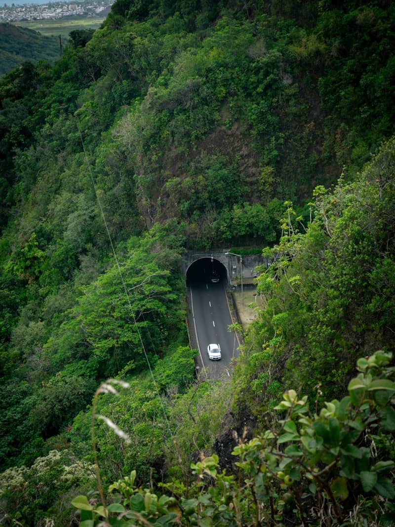 Car driving towards a tunnel on a mountain road