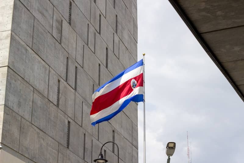 The costa rican flag flies proudly beside a modern building