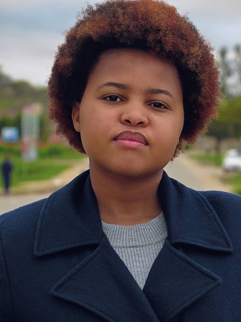A young woman stares at the camera.