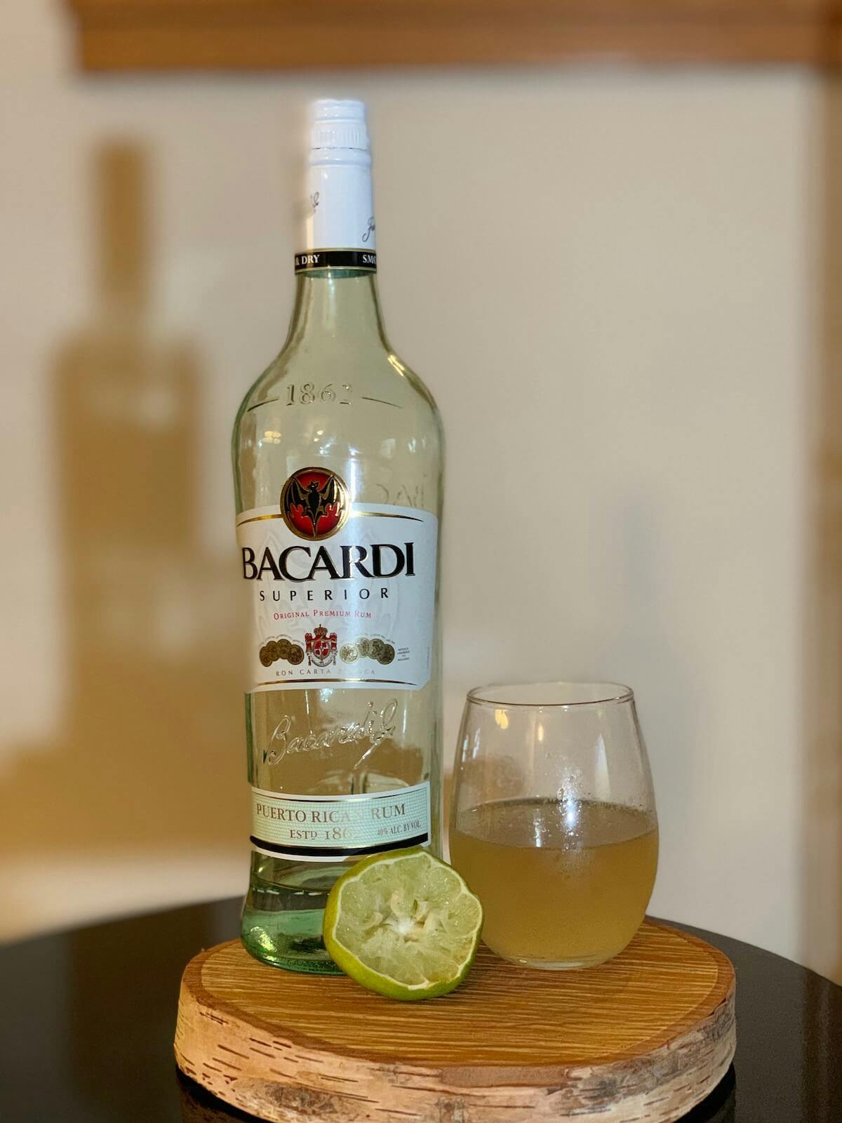 Daiquiri in a glass next to Bacardi Rum and a squeezed lime.