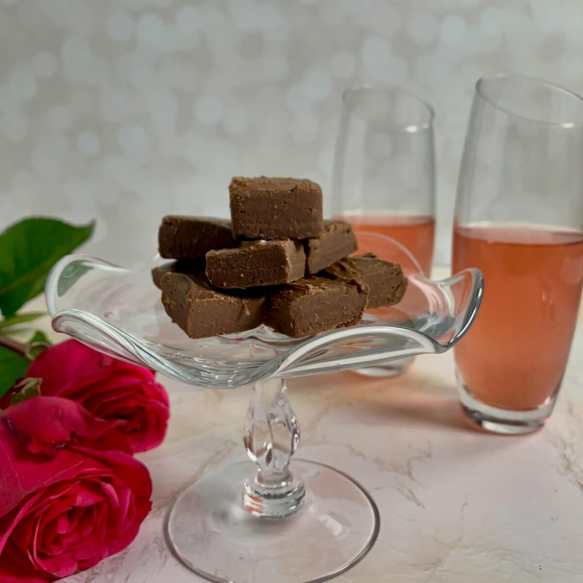 Dark chocolate whisky fudge stacked on a white plate.