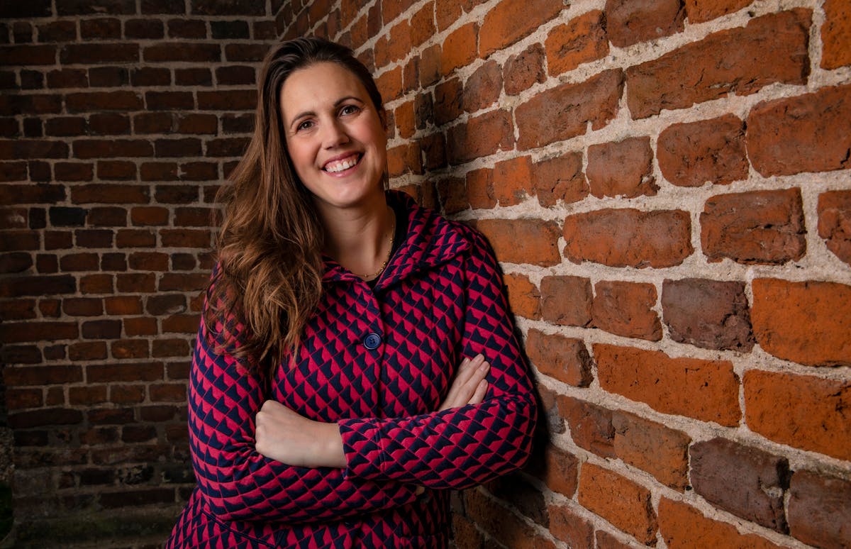 Marieke van de Rakt leaning against a brick wall