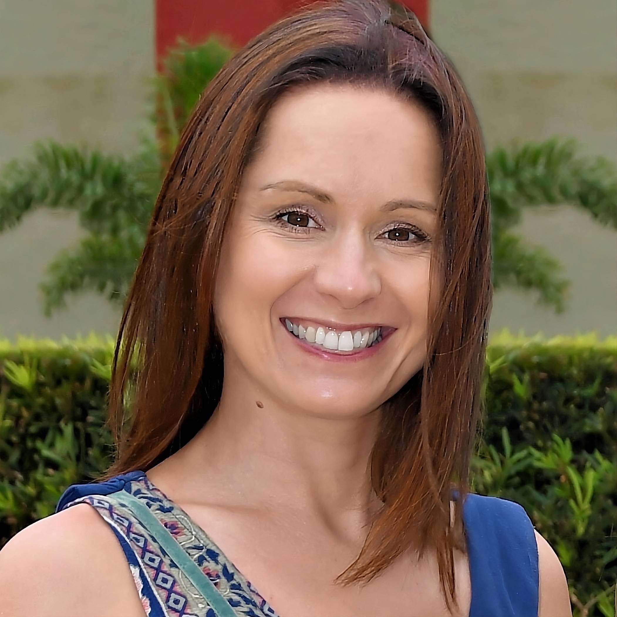Katie Keith, woman with bright smile and reddish brown shoulder length hair. 