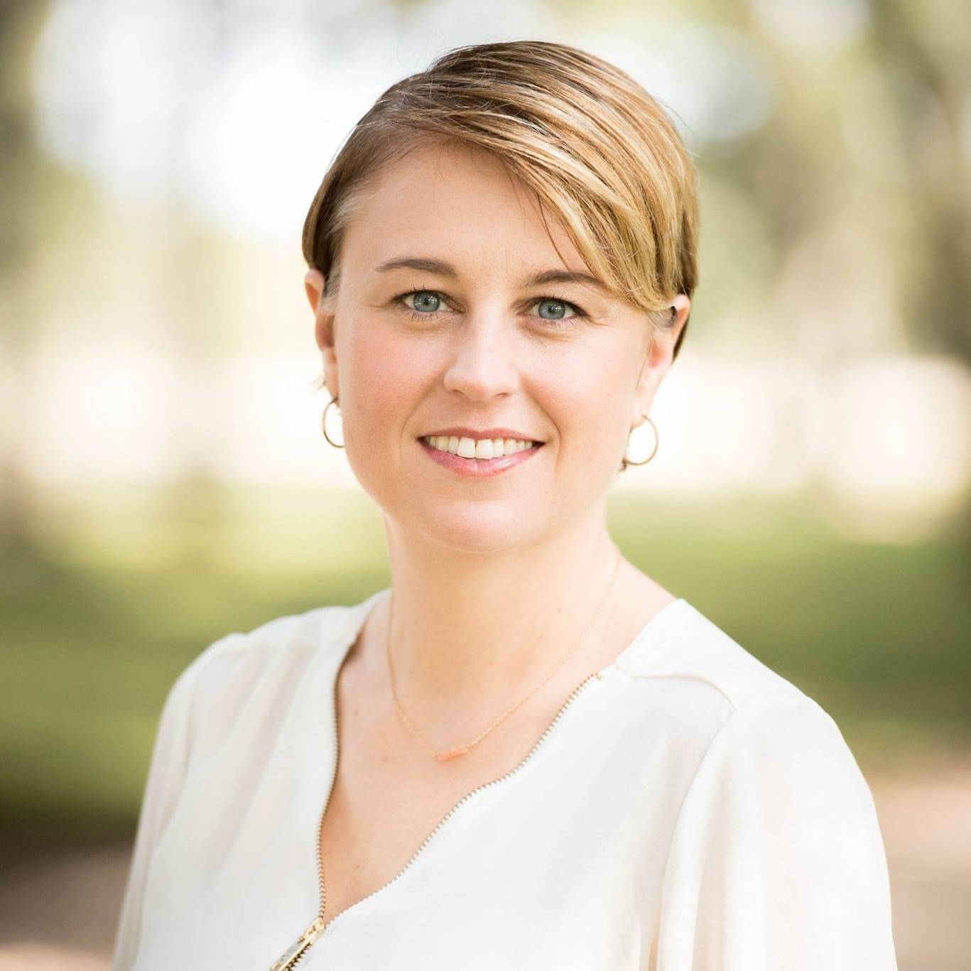 Kimberly Lipari is a white woman with blue eyes, a friendly smile, and short blonde hair. She's wearing a white shirt and thin gold necklace.