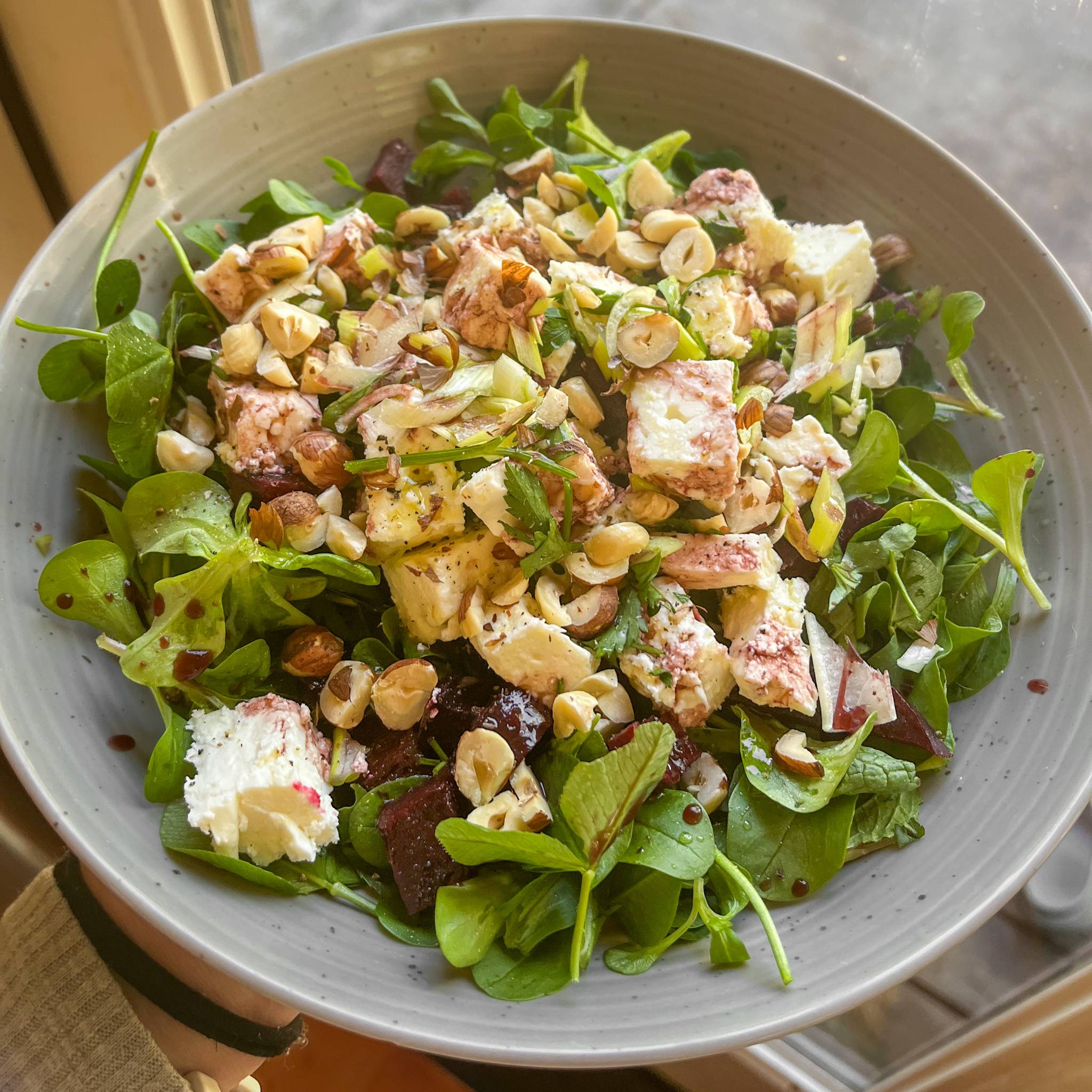 Mache Salad in a bowl with roasted beets, feta, and hazelnuts