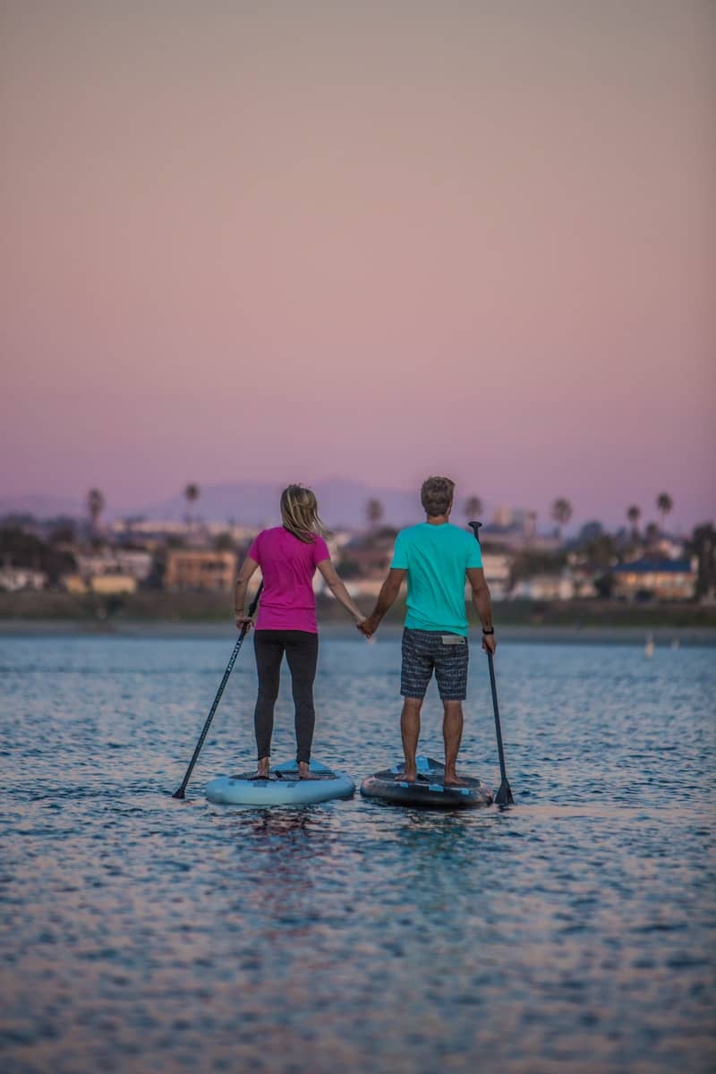 man and woman standing on blue and white boat on sea during daytime