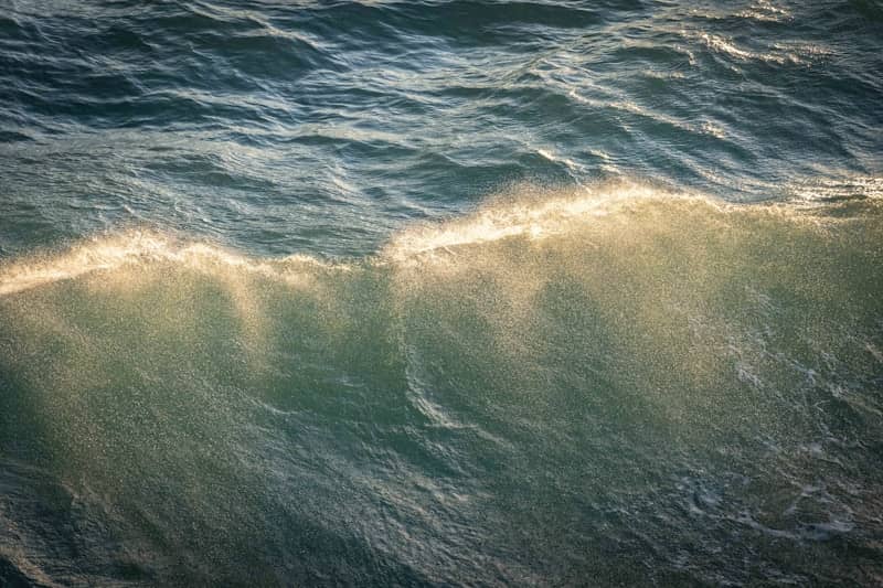 Sunlight glints on a breaking ocean wave