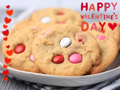 Five M&M Valentine's Day cookies on a plate with Happy Valentine's Day graphic in the right corner