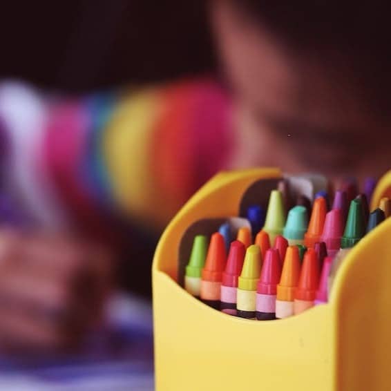 selective focal photo of crayons in yellow box