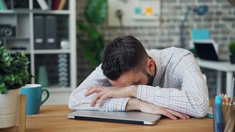 Leadership Stress a man sitting at a desk with his head in his hands