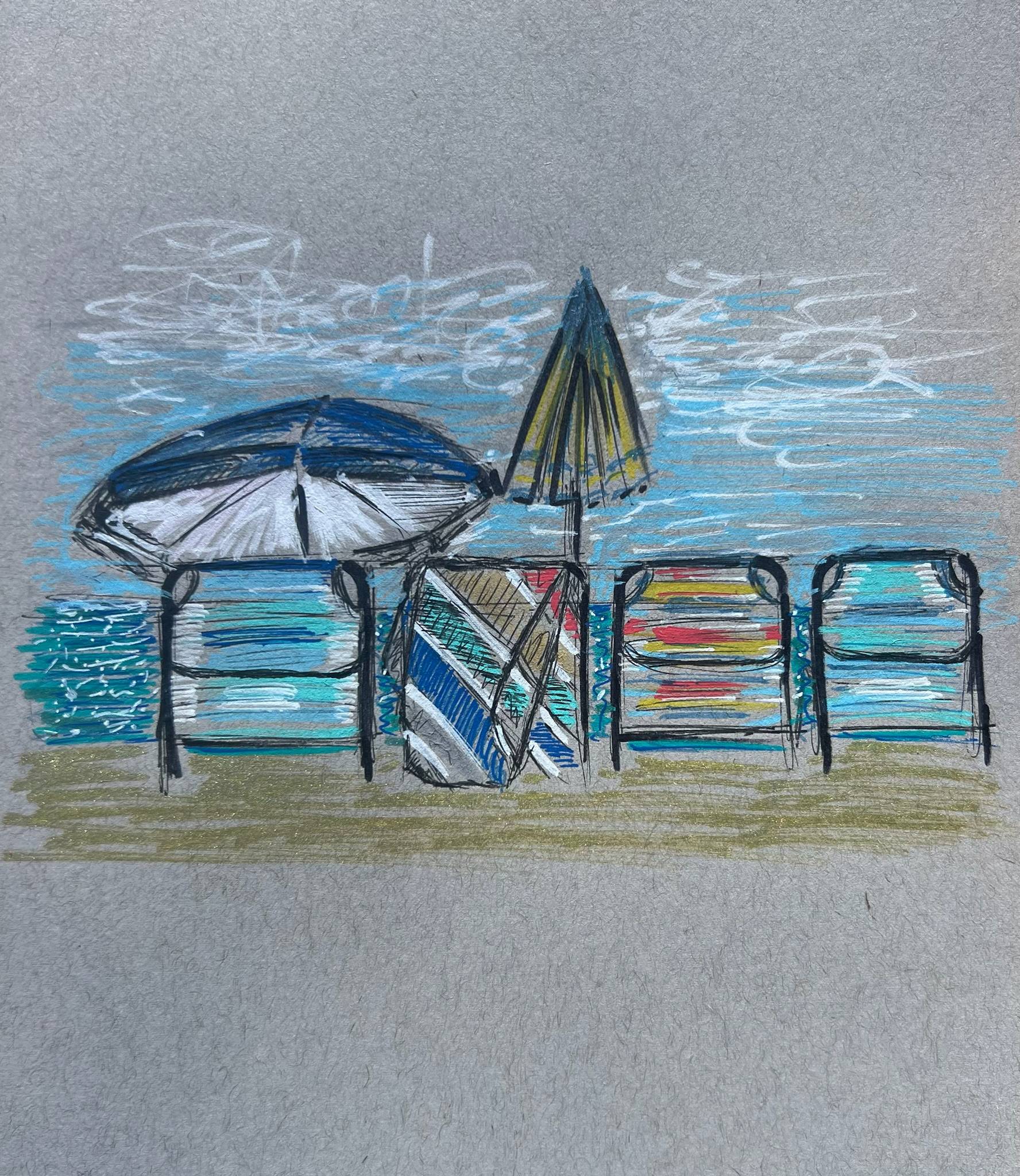 Hand-drawn beach scene on gray paper showing four lounge chairs arranged in a row facing the ocean. Each chair has horizontal stripes in different colors, including blue, red, yellow, and teal. Two beach umbrellas stand between the chairs: one open umbrella on the left in shades of blue and white, and a closed umbrella in the center with yellow and dark accents. The ocean is illustrated with layered blue strokes, and the sky above is light gray with white, cloud-like marks. The ground is sandy, drawn with muted tan and green tones. The drawing uses colored pencil and pen with visible sketch lines and texture.