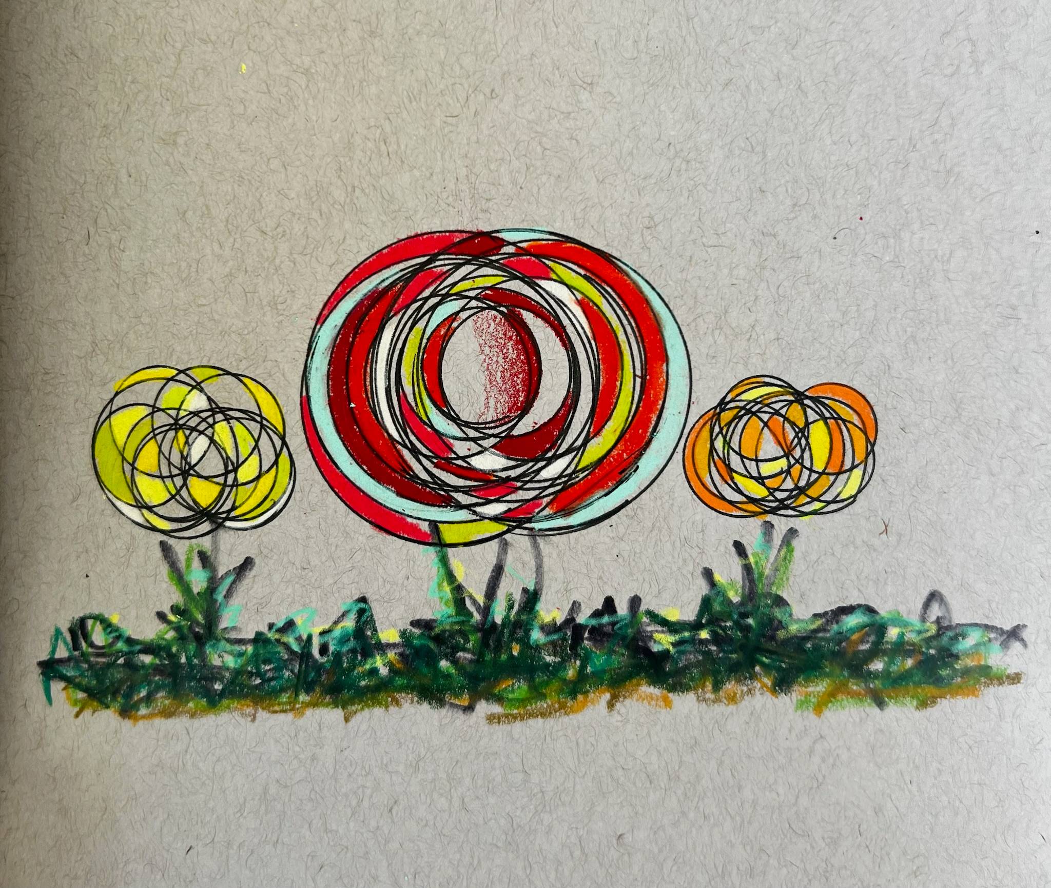 A hand-drawn illustration of three stylized flowers growing from a patch of scribbled green grass. The flowers are made of overlapping circular loops in black, creating a layered, swirling effect. The center flower is the largest, colored in red, light blue, and yellow with a textured red center. The two smaller flowers on either side use yellow and orange tones. The background is plain off-white paper with visible texture.