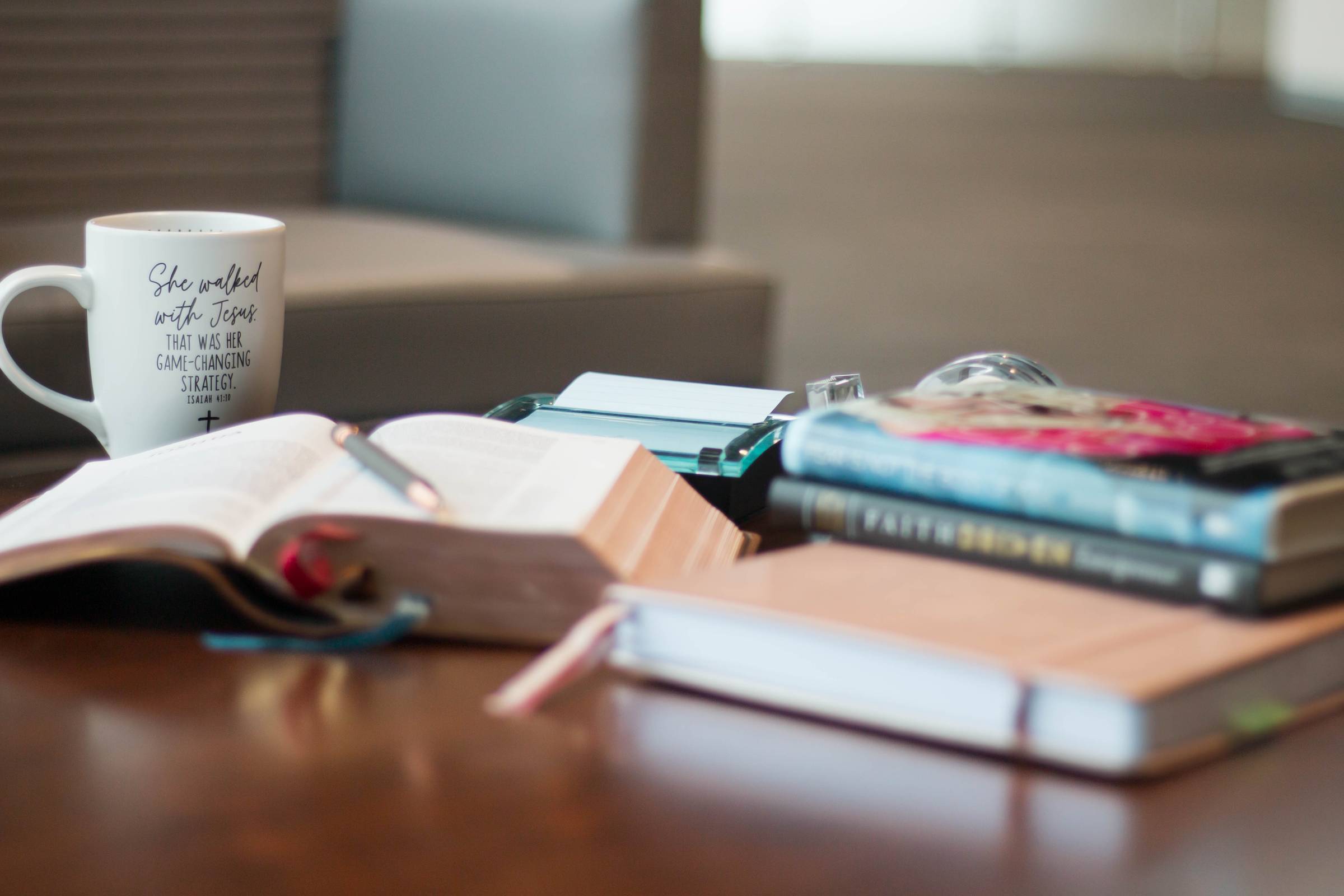 MacBook Air beside gold-colored study lamp and spiral books