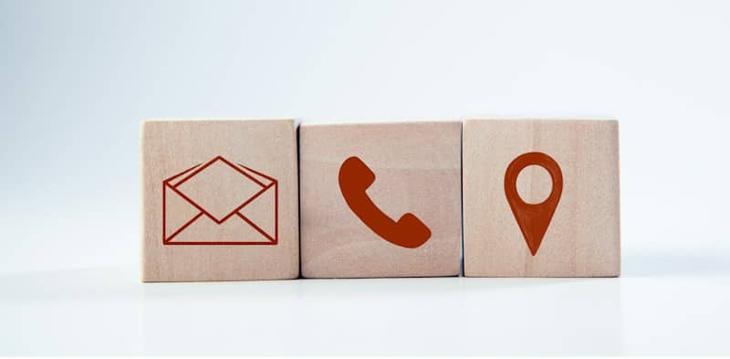 Wooden blocks with contact icons: envelope, phone, location