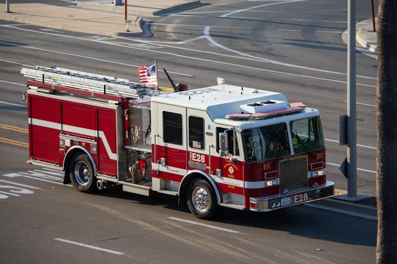 A red and white fire truck driving down a street