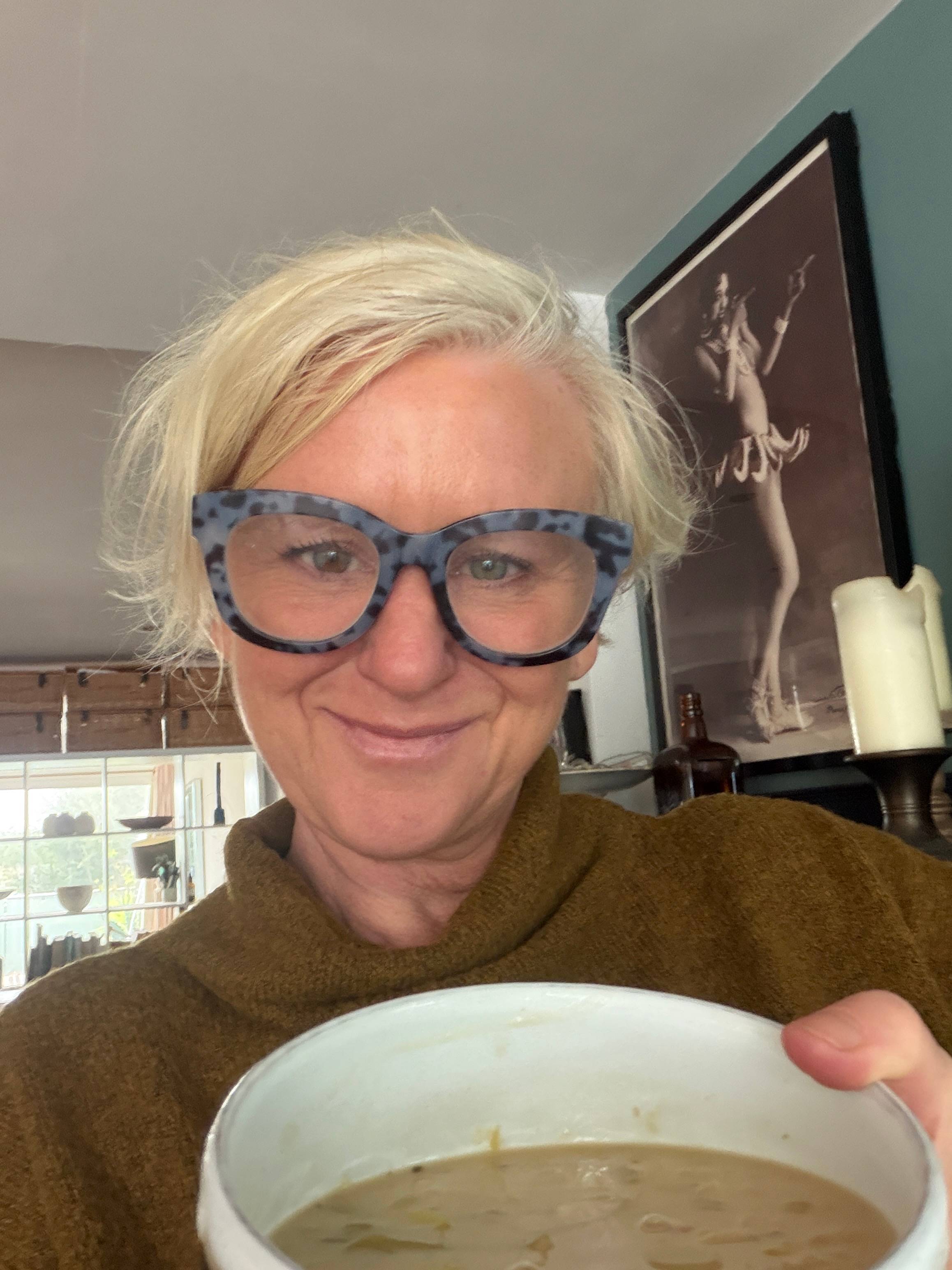 Rebecca smiling with a bowl of leek and white bean soup