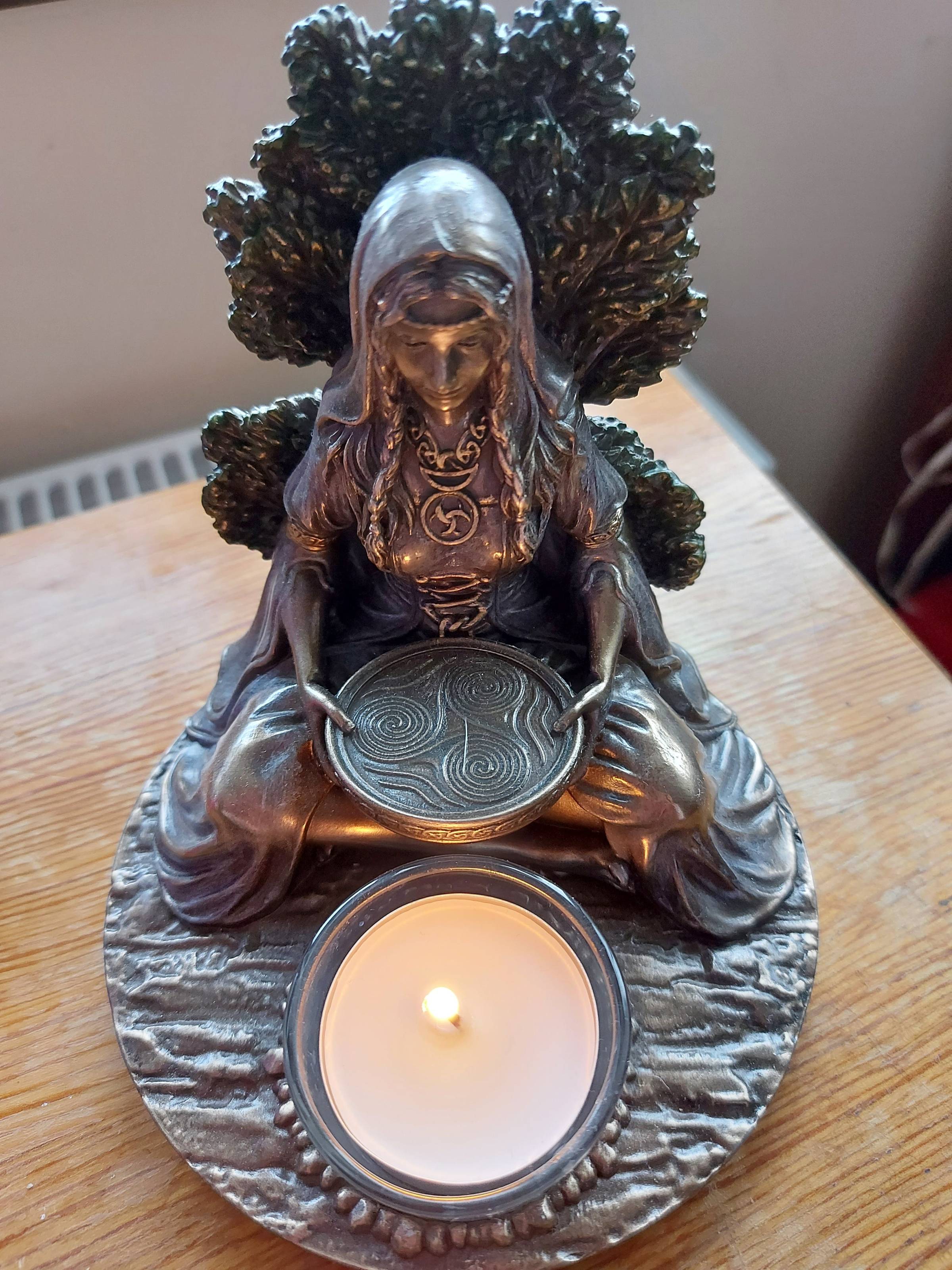 Image of my Brigid statue with a candle lit in the appropriate well