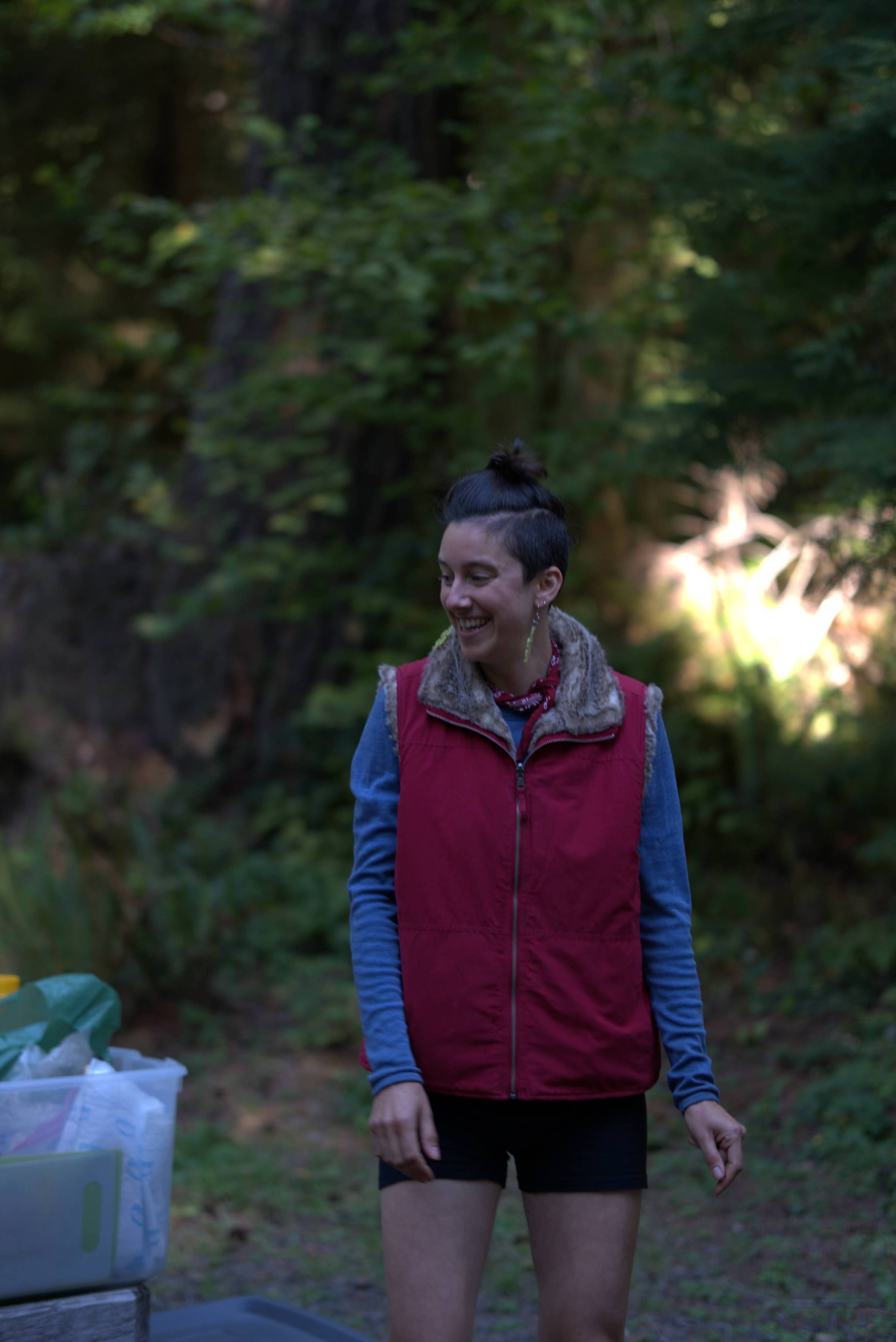 Happy genderqueer human smiling in the woods