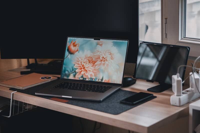 A laptop computer sitting on top of a wooden desk