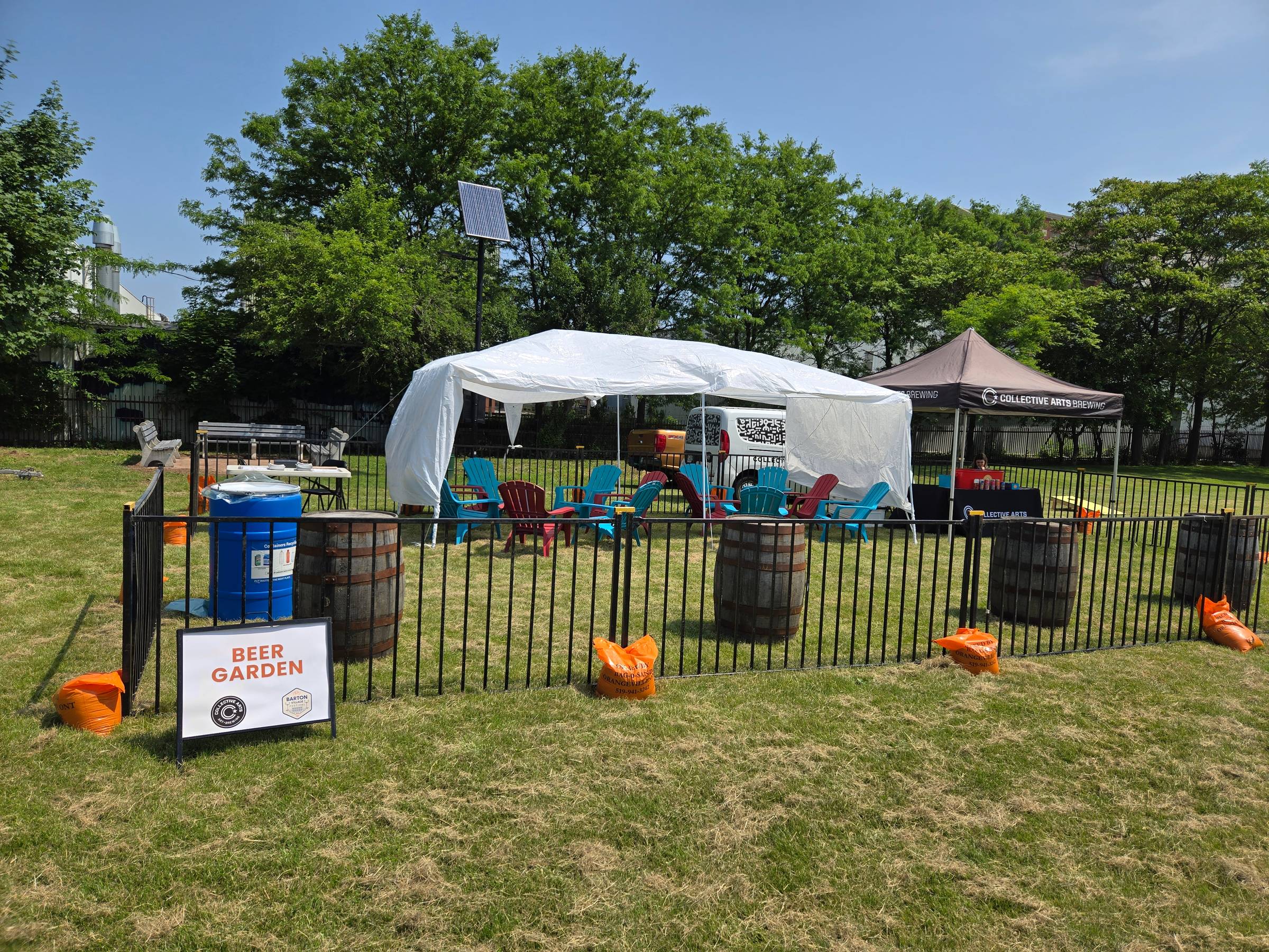 Small outdoor beer garden with chairs, tents, and a "Beer Garden" sign.