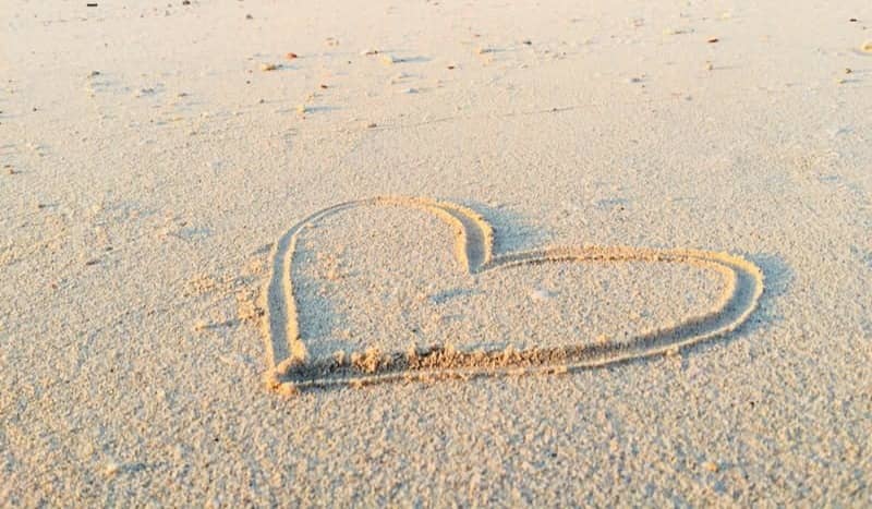 heart drawn on sand during daytime