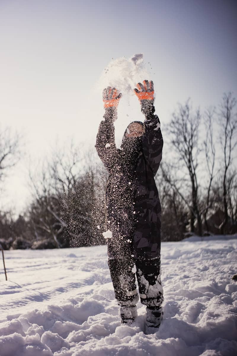 A child throws snow in the air.