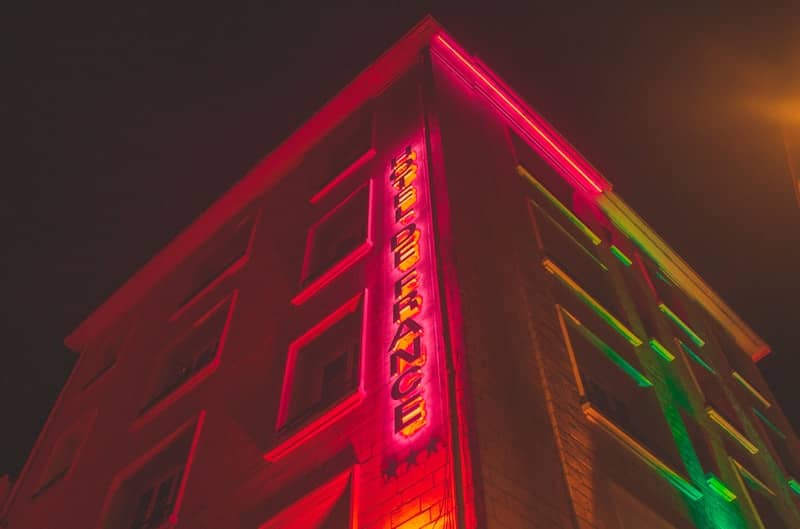 a tall building with a neon sign on it's side