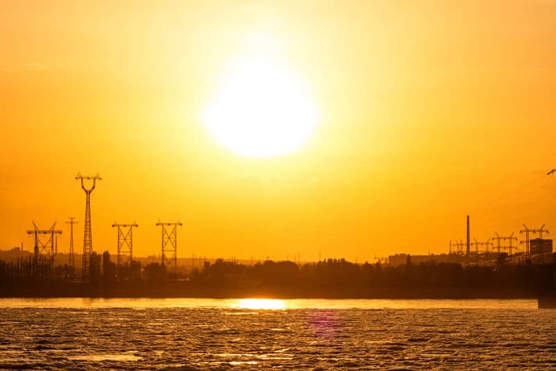 Sunset over a lake with power lines on the horizon.