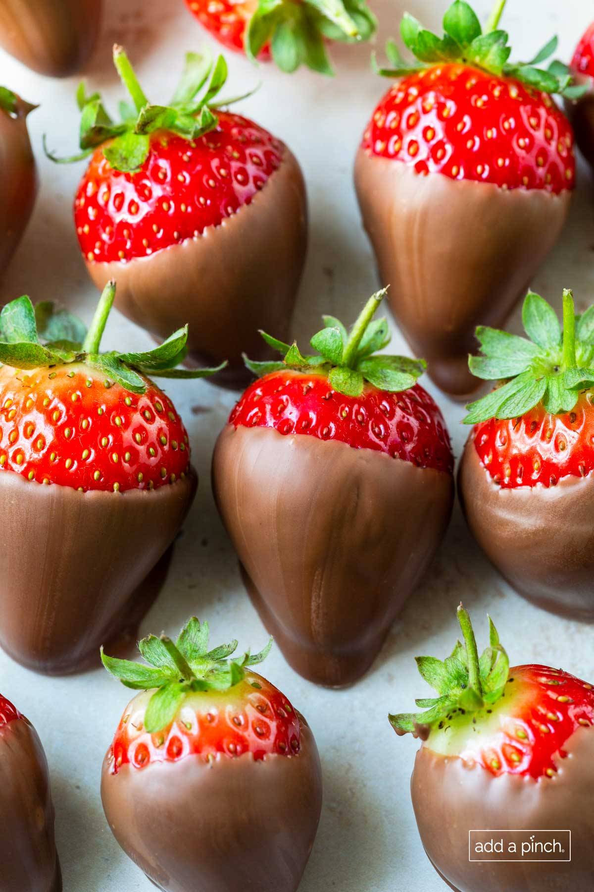 Chocolate covered strawberries on a white surface. 