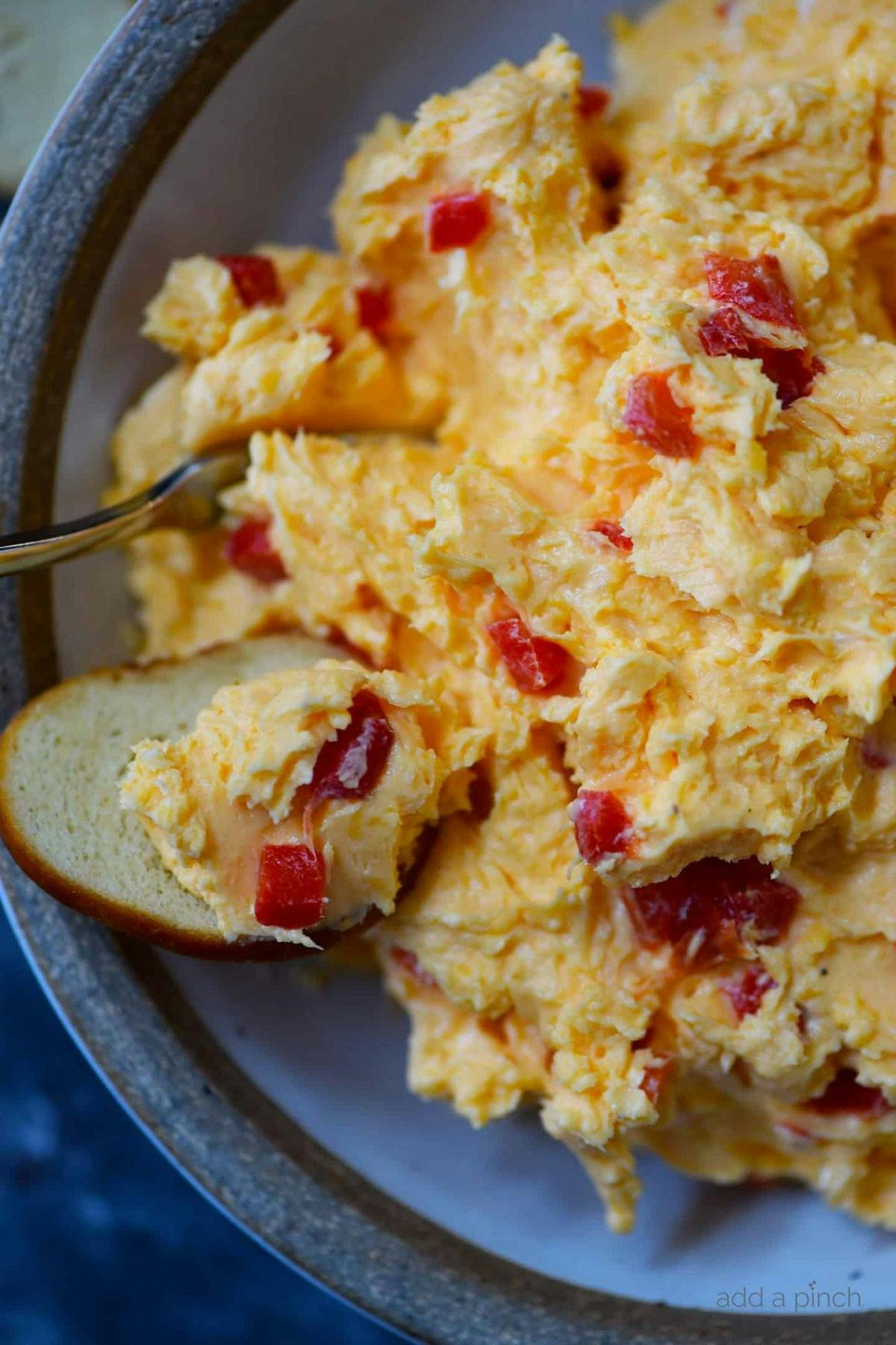 Overhead photograph of pimento cheese in a bowl with a cracker. 