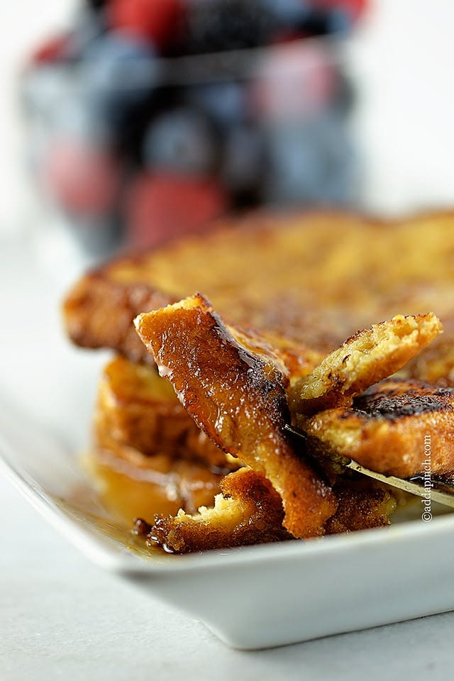 Up close photograph of French toast on a fork. 