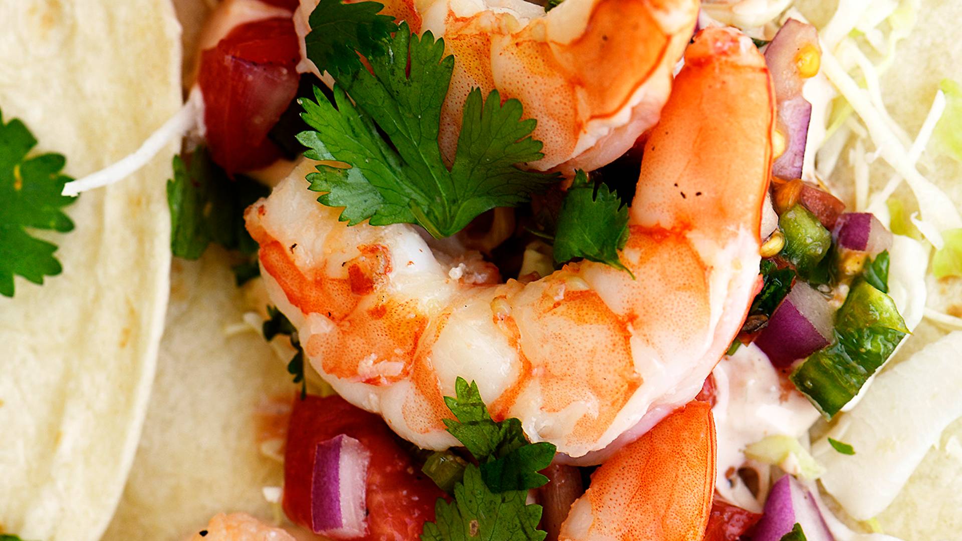 Easy shrimp tacos on flour tortilla with onions and fresh cilantro.