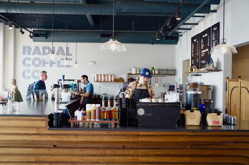 Barista preparing drinks behind a coffee shop counter