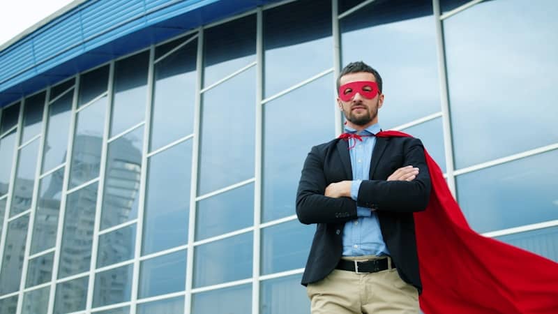 Man in superhero costume standing outside modern building