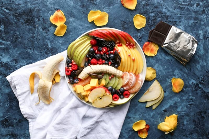 bowl of sliced fruits on white textile